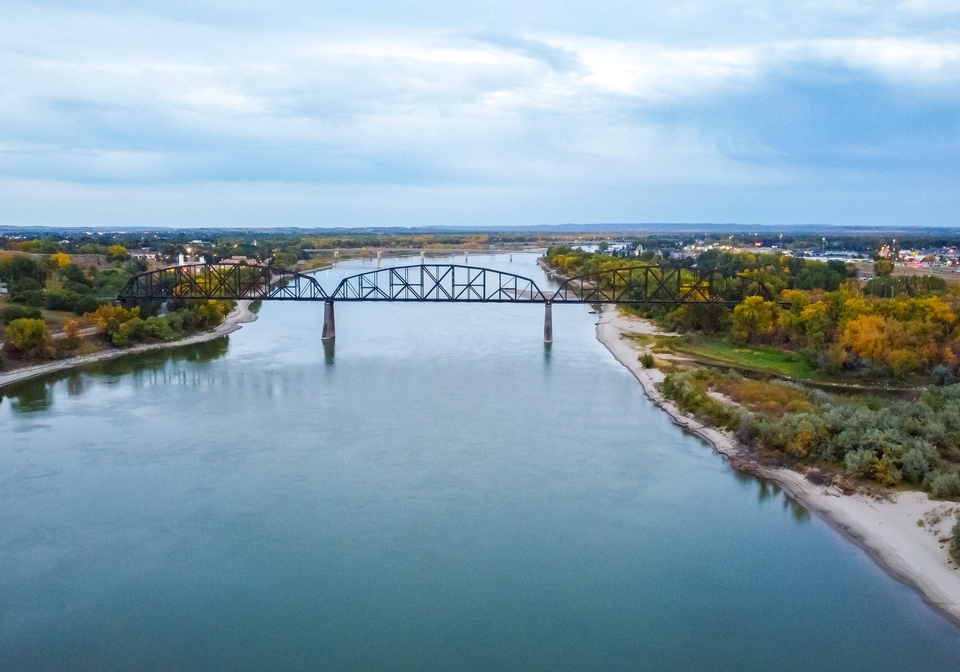 A bridge over the water with trees in the background