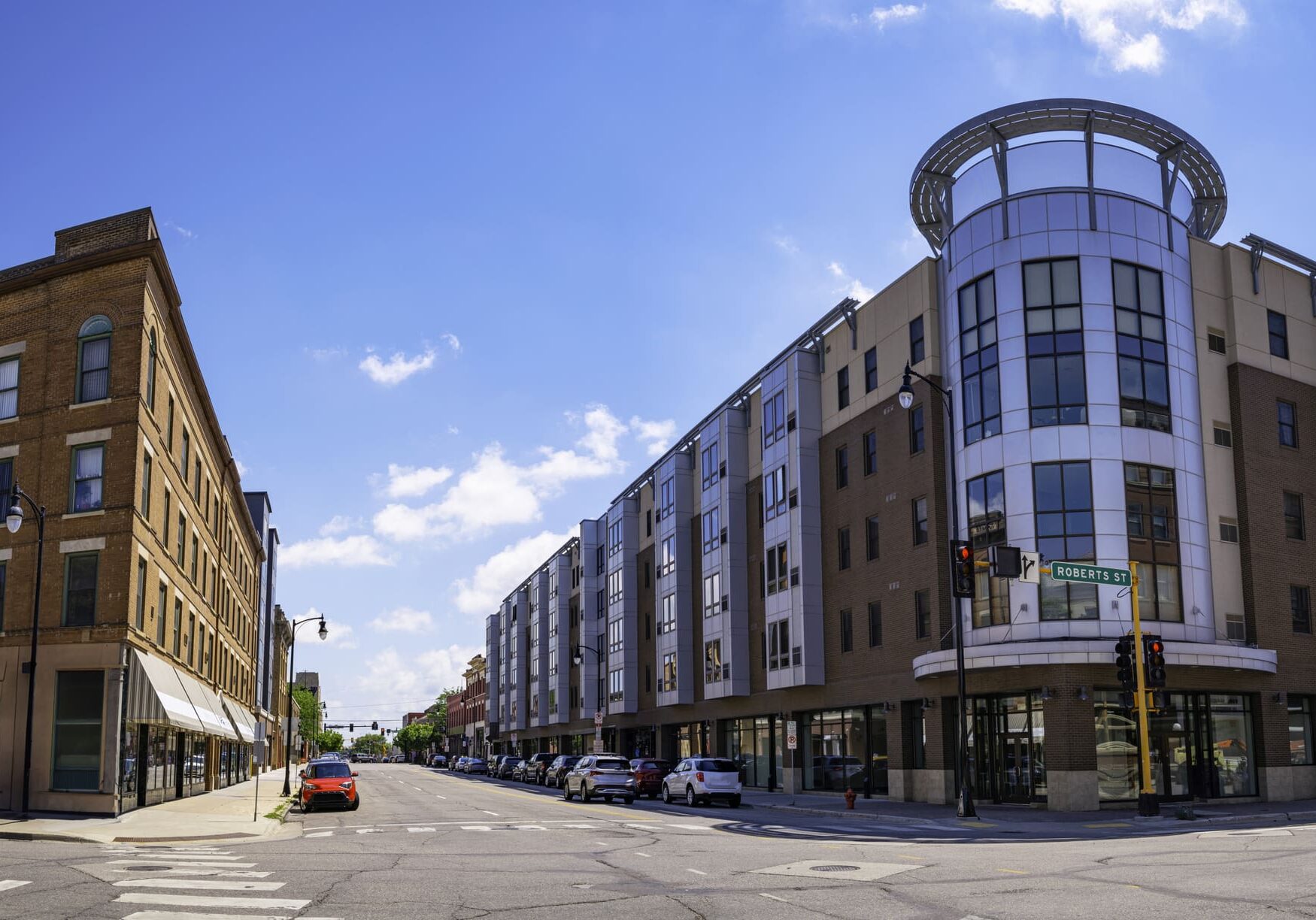 A street with many buildings and cars on the side.