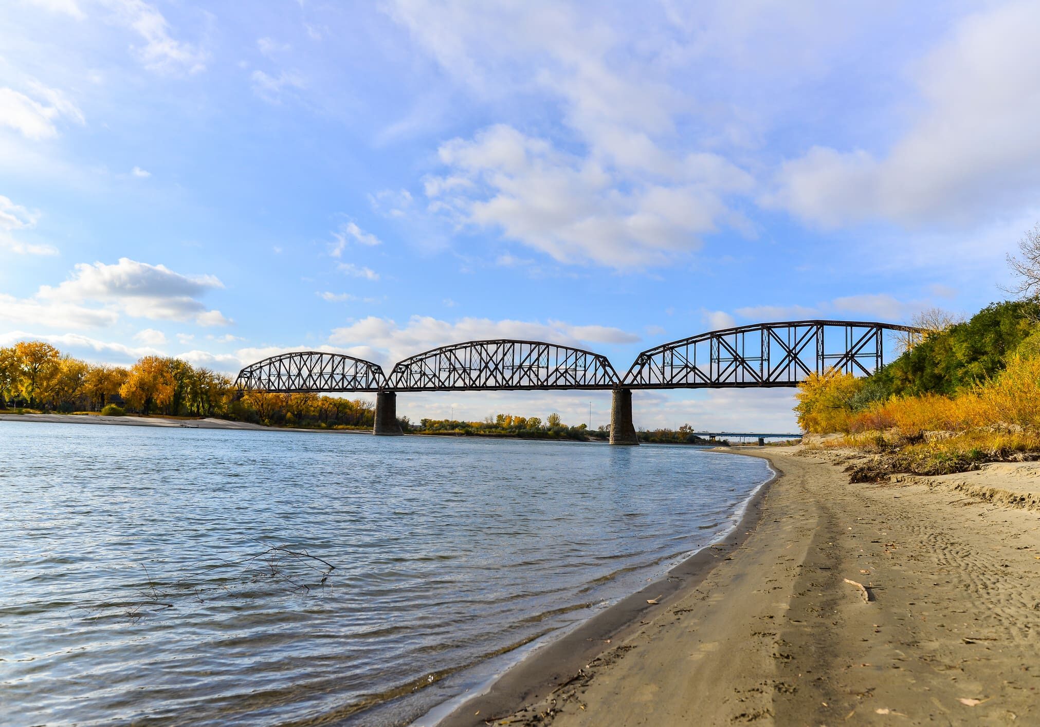 A bridge over water with trees in the background