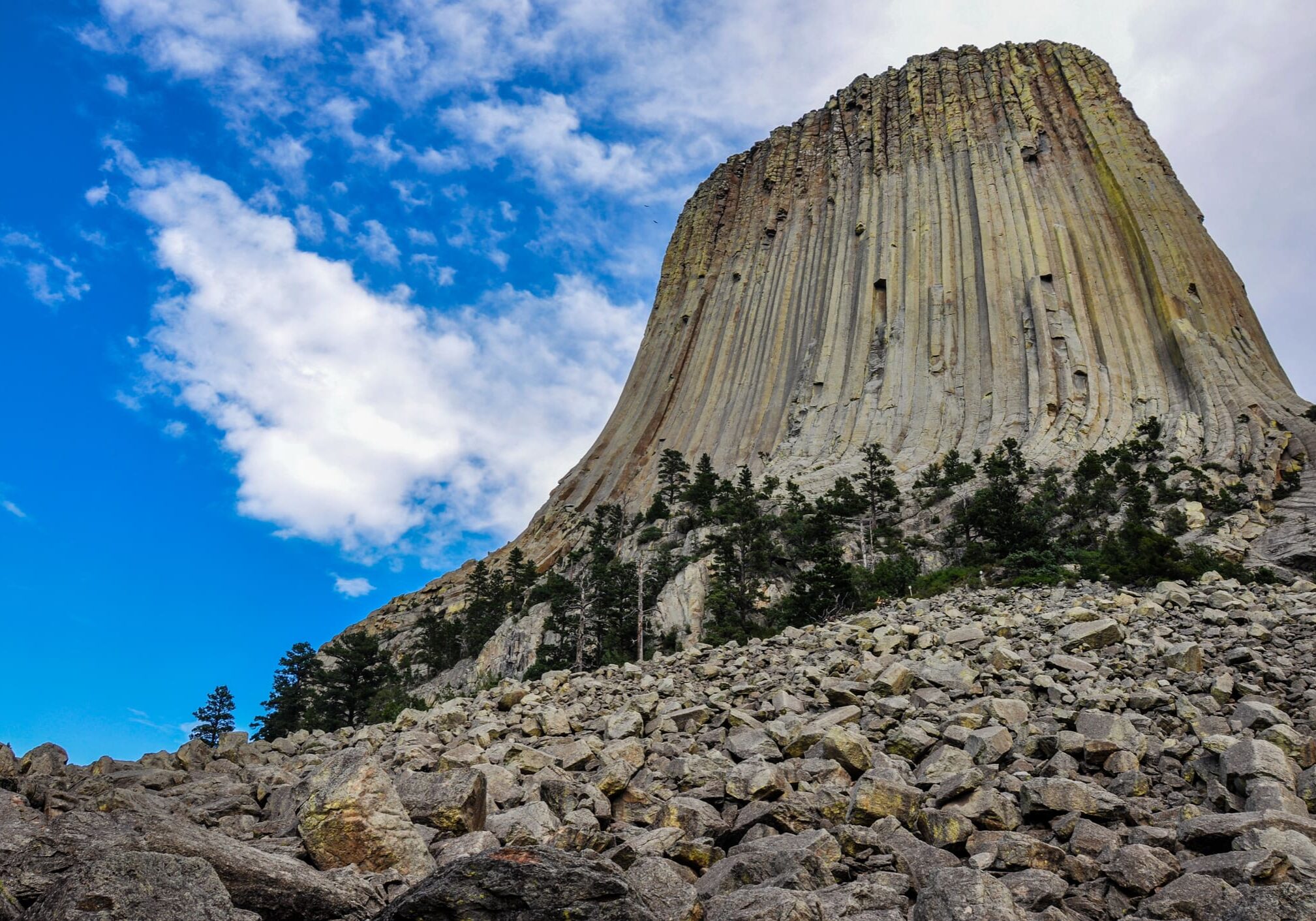 A large rock formation with trees in the foreground.